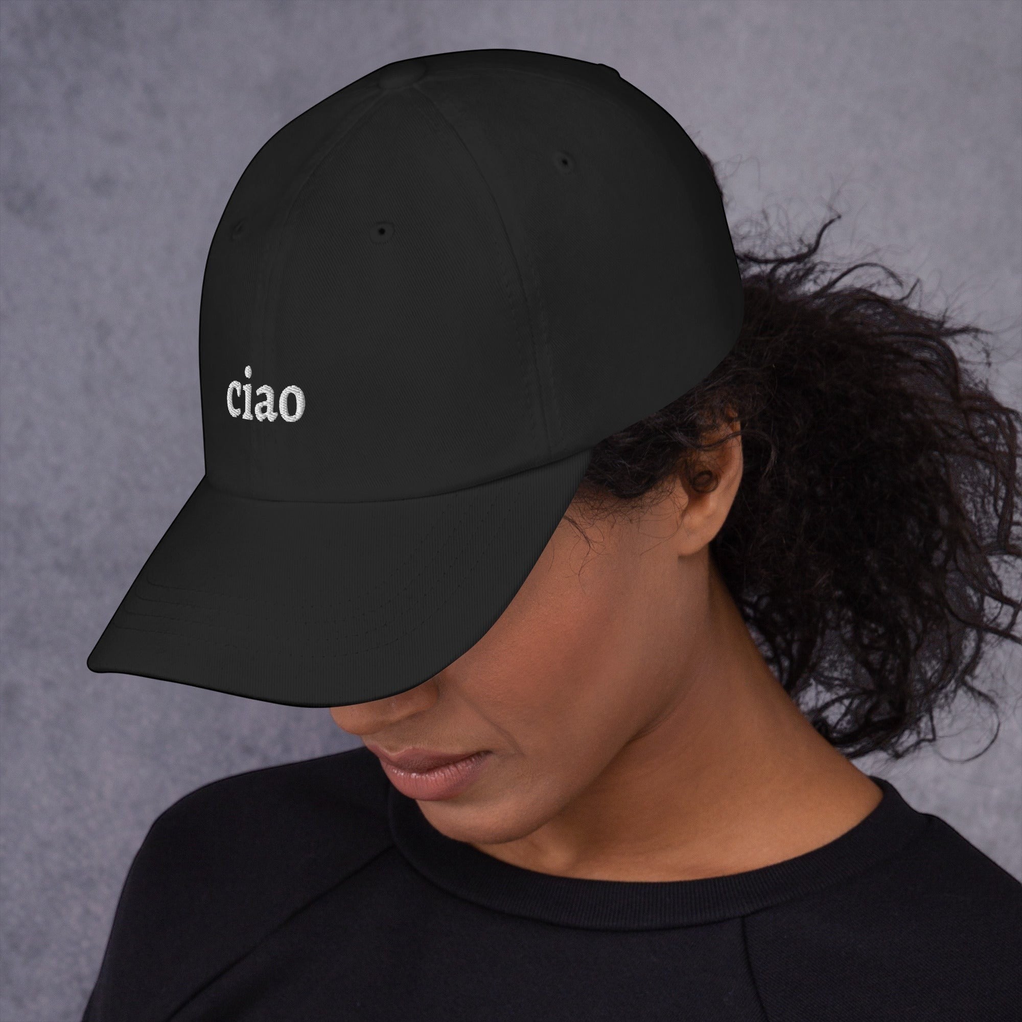 Say Ciao Coffee black cotton twill baseball cap with embroidered "ciao" logo and curved visor, worn by a woman.