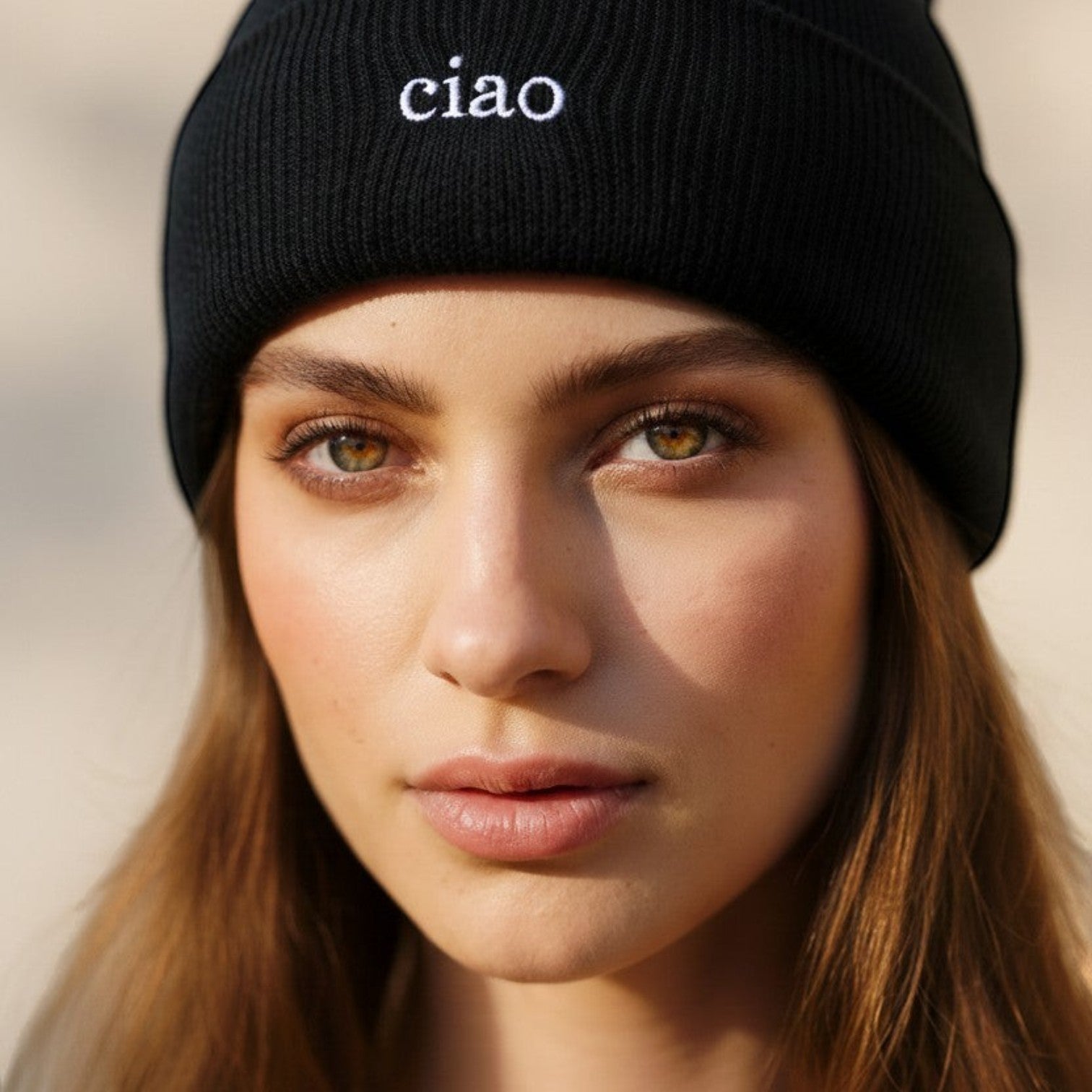 Say Ciao Coffee black ribbed knit beanie with white "ciao" embroidery. Model wears beanie outdoors.